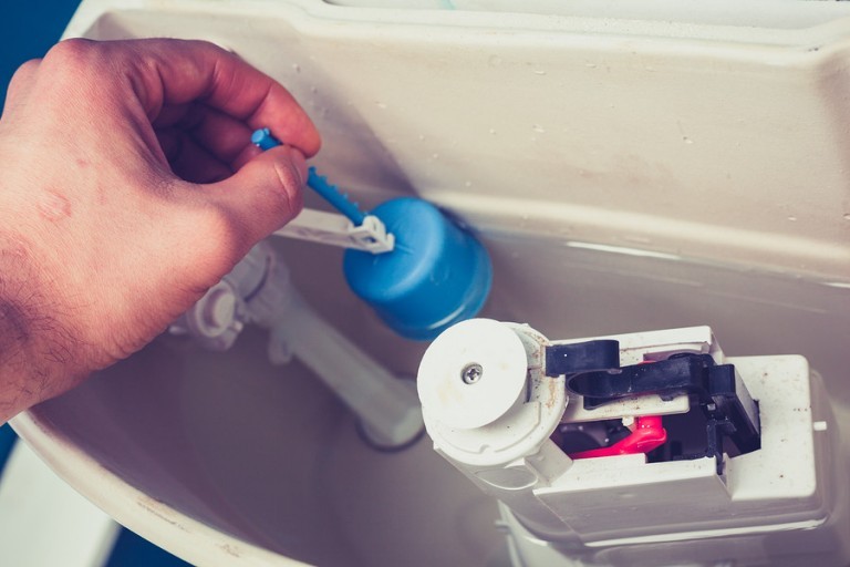 checking plumbing in toilet